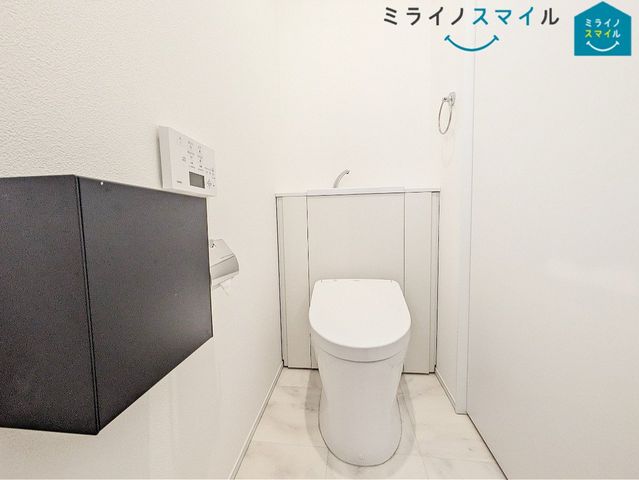 手洗い場付きのタンクレストイレ。タンクがない分スペースが広く感じられ、リモコンも壁かけタイプで操作がしやすい◎